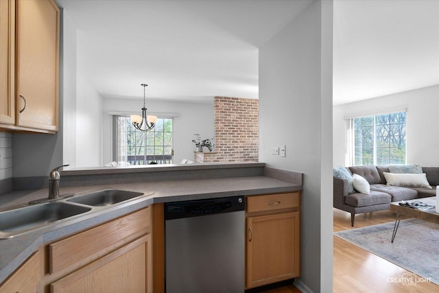 kitchen featuring stainless steel dishwasher, light wood-type flooring, a sink, a chandelier, and open floor plan
