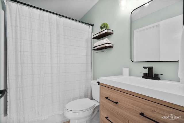 bathroom with toilet, vanity, and a shower with shower curtain