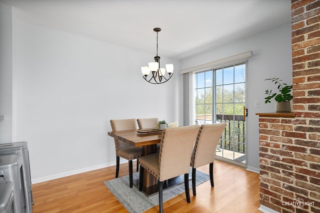 dining area with a chandelier, light wood-style flooring, and baseboards