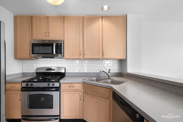 kitchen with appliances with stainless steel finishes, a sink, light brown cabinets, backsplash, and recessed lighting