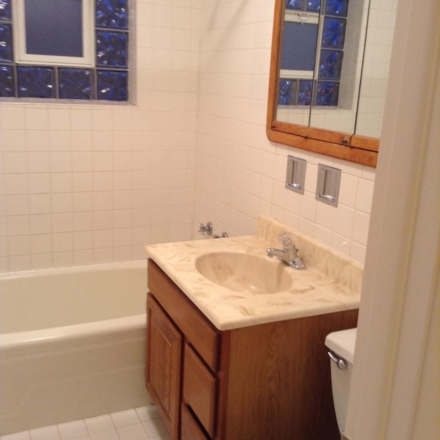 960 Shermer Rd Unit 2, Glenview, IL 60025 - bathroom with toilet, vanity, tile walls, a tub to relax in, and tasteful backsplash