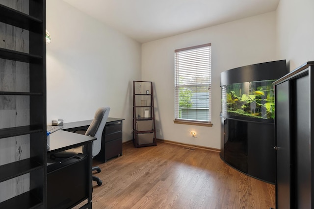 office area featuring light wood-type flooring and baseboards