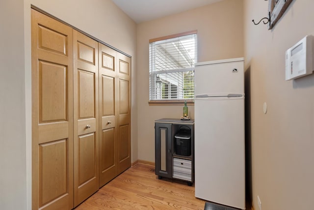kitchen with freestanding refrigerator, light wood finished floors, and baseboards