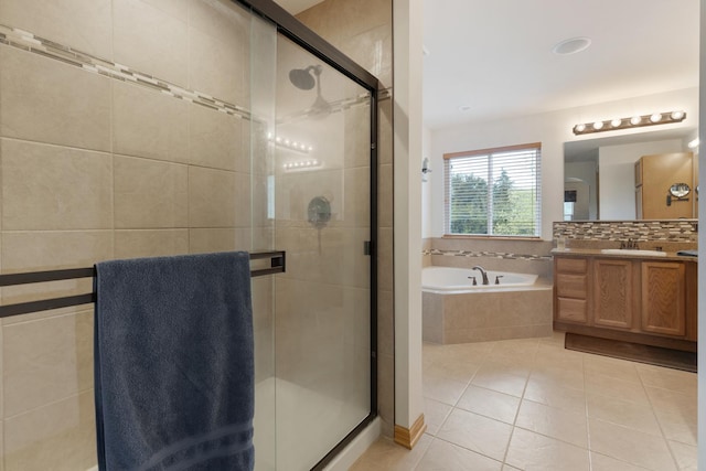 bathroom featuring a bath, vanity, a stall shower, and tile patterned flooring