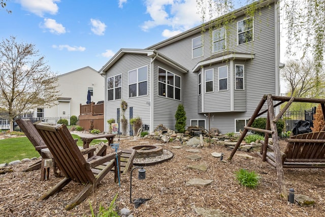 rear view of property featuring an outdoor fire pit