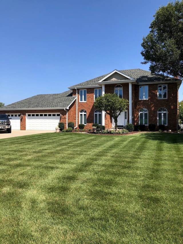 view of front facade featuring a garage, brick siding, driveway, and a front lawn