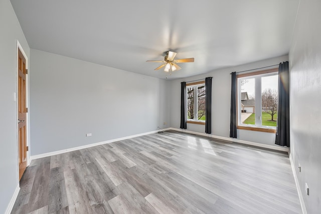 empty room with baseboards, a ceiling fan, and wood finished floors