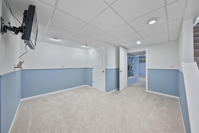 below grade area featuring carpet floors and a wainscoted wall