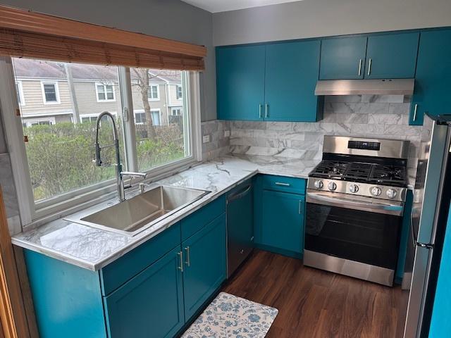 1968 Holbrook Ln, Hoffman Estates, IL 60169 - kitchen featuring a sink, under cabinet range hood, stainless steel appliances, dark wood-type flooring, and blue cabinetry