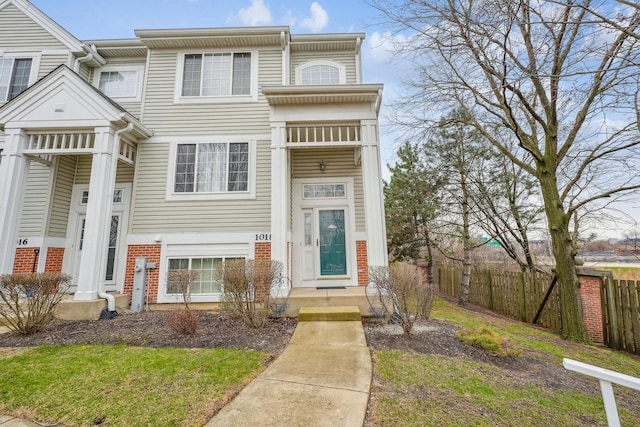 view of front of home featuring brick siding and fence