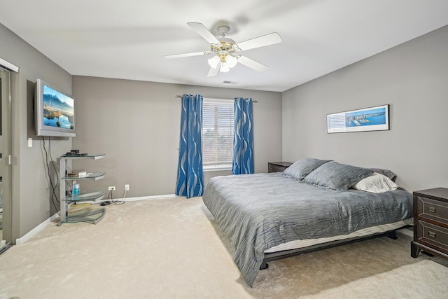 carpeted bedroom with visible vents, baseboards, and ceiling fan