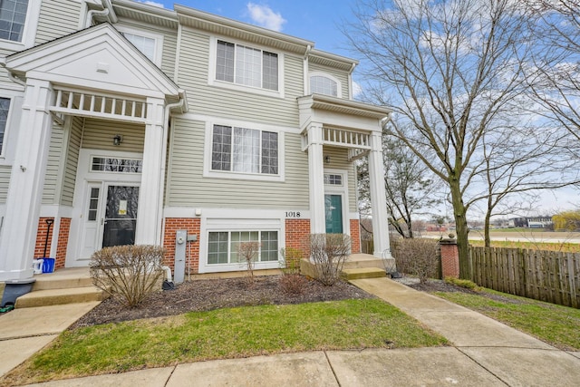 townhome / multi-family property with brick siding and fence