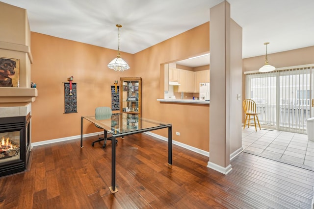recreation room featuring a chandelier, a tile fireplace, baseboards, and dark wood-style floors