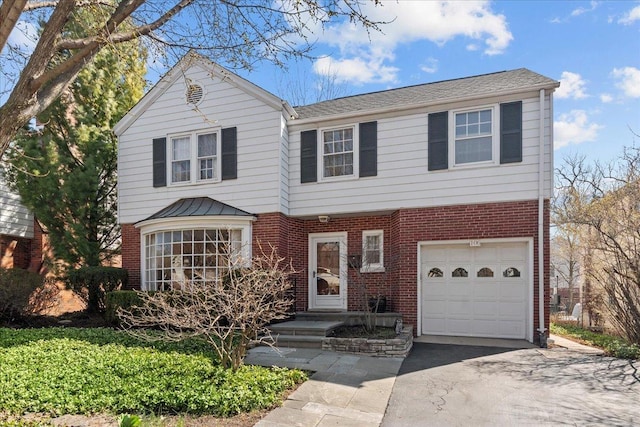 traditional-style house with aphalt driveway, brick siding, and an attached garage