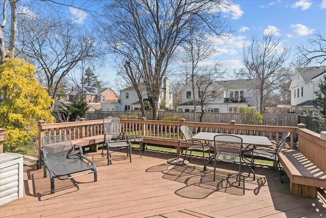 wooden deck featuring outdoor dining space, fence, and a residential view