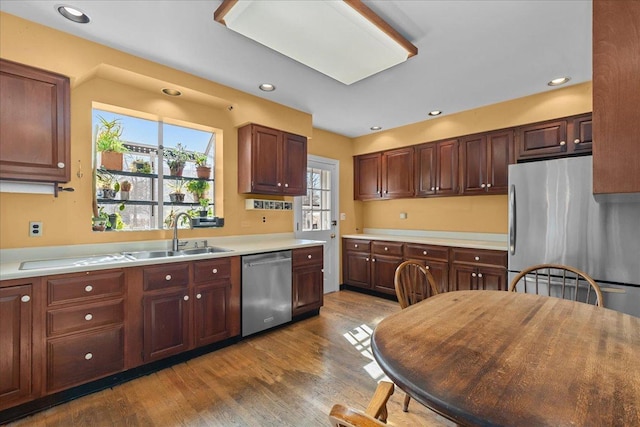 kitchen featuring wood finished floors, a sink, a wealth of natural light, and stainless steel appliances