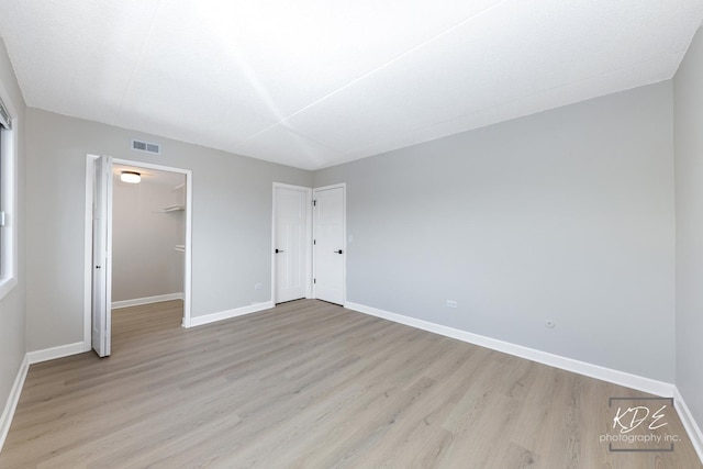 1221 Chalet Rd Unit 28-201, Naperville, IL 60563 - unfurnished bedroom with light wood-style flooring and a walk in closet