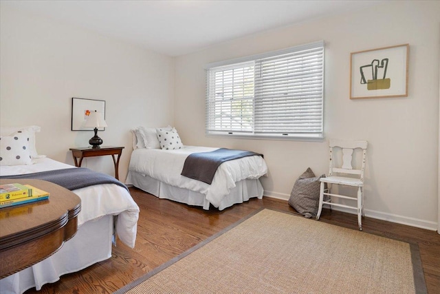 bedroom with baseboards and wood finished floors