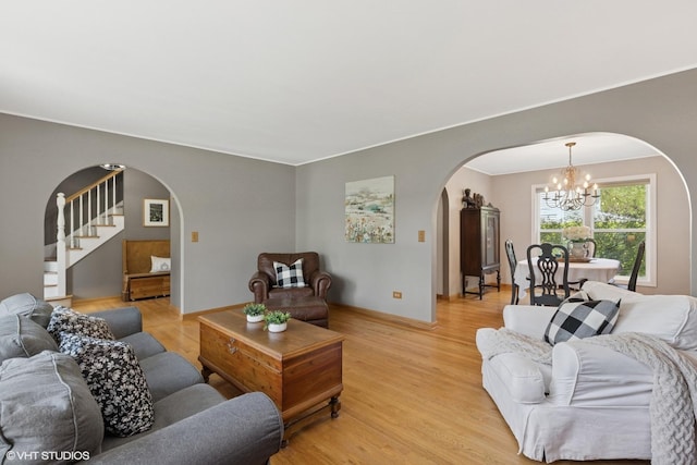 1900 Buckingham Rd, Mundelein, IL 60060 - living area with arched walkways, a chandelier, light wood-style flooring, baseboards, and stairway