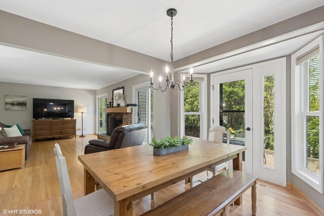 1900 Buckingham Rd, Mundelein, IL 60060 - dining room featuring light wood-style floors, a fireplace, and a chandelier