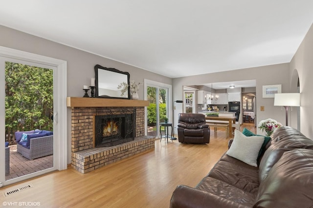 1900 Buckingham Rd, Mundelein, IL 60060 - living area with a fireplace, light wood finished floors, and a chandelier