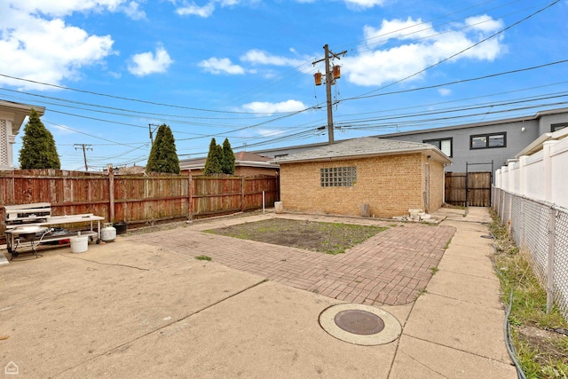 back of property featuring a patio, brick siding, and a fenced backyard