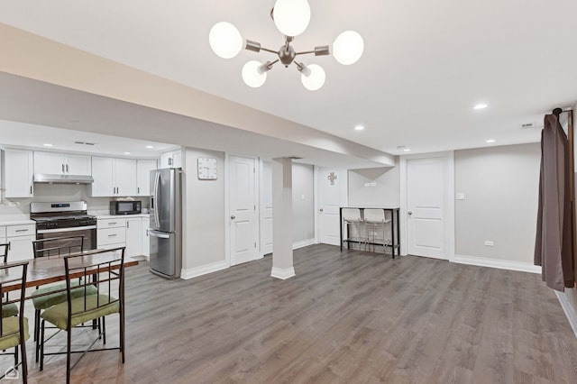 interior space featuring stainless steel refrigerator with ice dispenser, wood finished floors, recessed lighting, and baseboards
