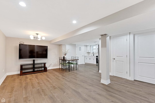 living room featuring baseboards, visible vents, light wood-style flooring, and recessed lighting