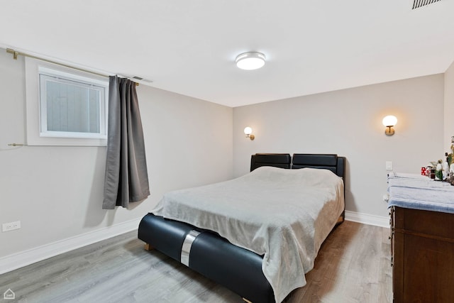 bedroom featuring visible vents, wood finished floors, and baseboards