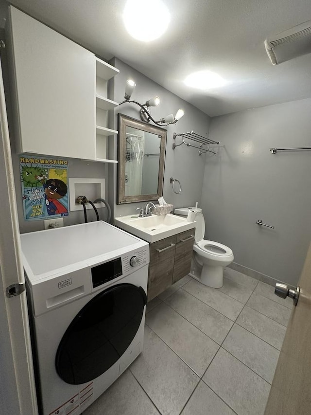 full bath featuring baseboards, toilet, vanity, tile patterned floors, and washer / dryer
