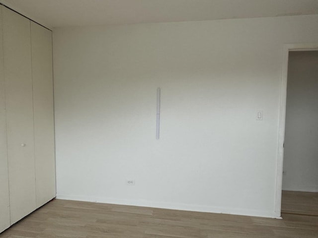 spare room featuring light wood finished floors and baseboards