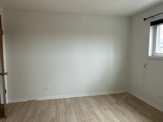 unfurnished room with light wood-style flooring and baseboards