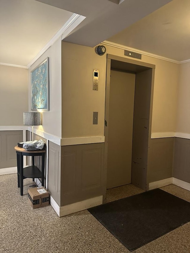 interior space featuring ornamental molding and a wainscoted wall