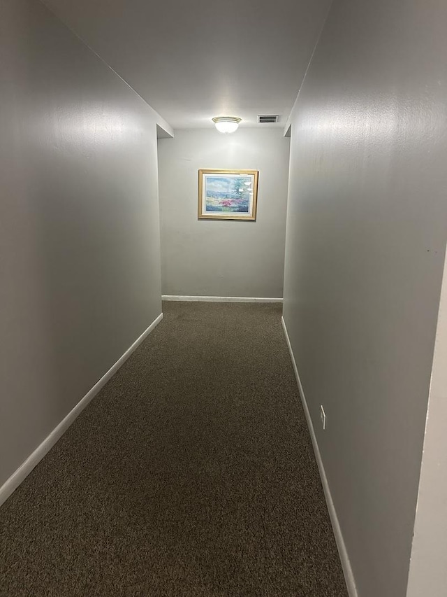 corridor with visible vents, baseboards, and carpet flooring
