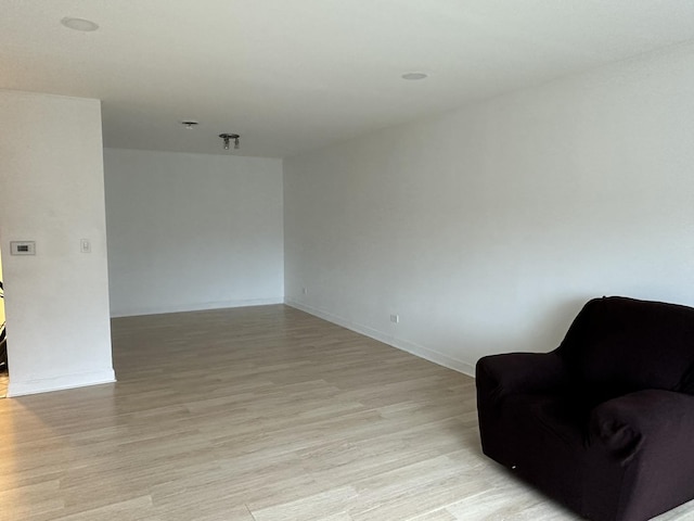 sitting room featuring baseboards and light wood finished floors
