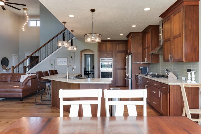 3605 Como Ct, Normal, IL 61761 - kitchen with stainless steel appliances, a kitchen island with sink, wall chimney range hood, wood finished floors, and a sink