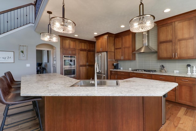 3605 Como Ct, Normal, IL 61761 - kitchen featuring stainless steel appliances, a sink, arched walkways, wall chimney range hood, and a spacious island