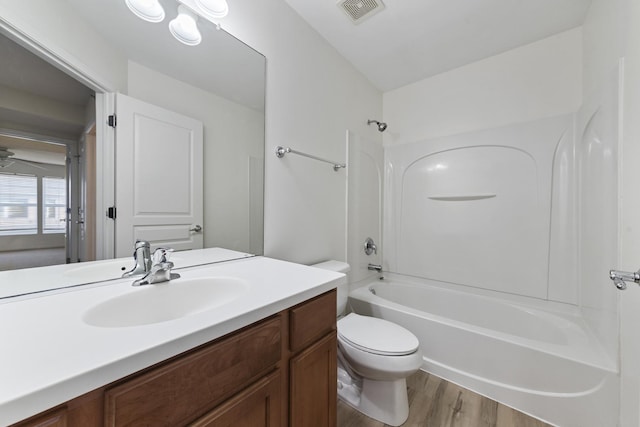 full bath featuring vanity, visible vents,  shower combination, toilet, and wood finished floors