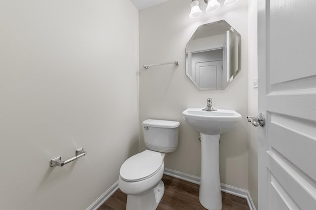 bathroom featuring baseboards, toilet, and wood finished floors