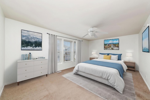 bedroom featuring light carpet, baseboards, and a ceiling fan