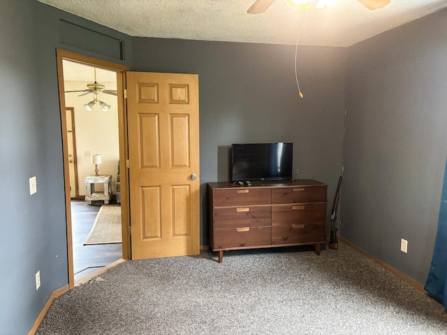 carpeted bedroom featuring a textured ceiling, ceiling fan, and baseboards