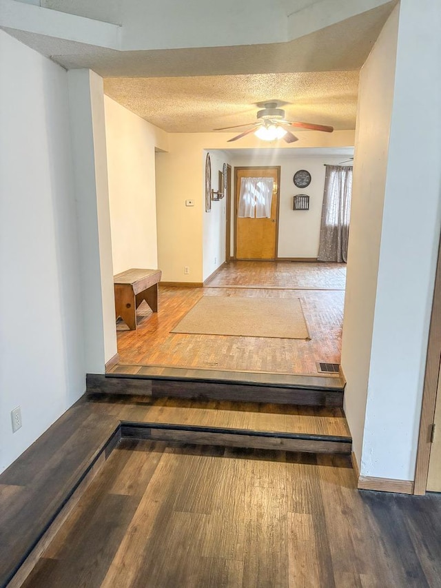 foyer entrance featuring visible vents, ceiling fan, a textured ceiling, and wood finished floors