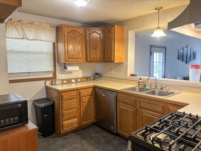kitchen with a sink, brown cabinetry, dark tile patterned floors, and dishwasher