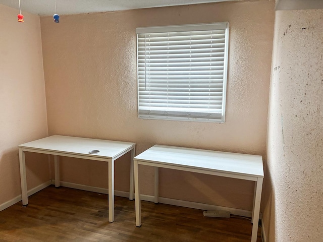 unfurnished office with baseboards and wood finished floors