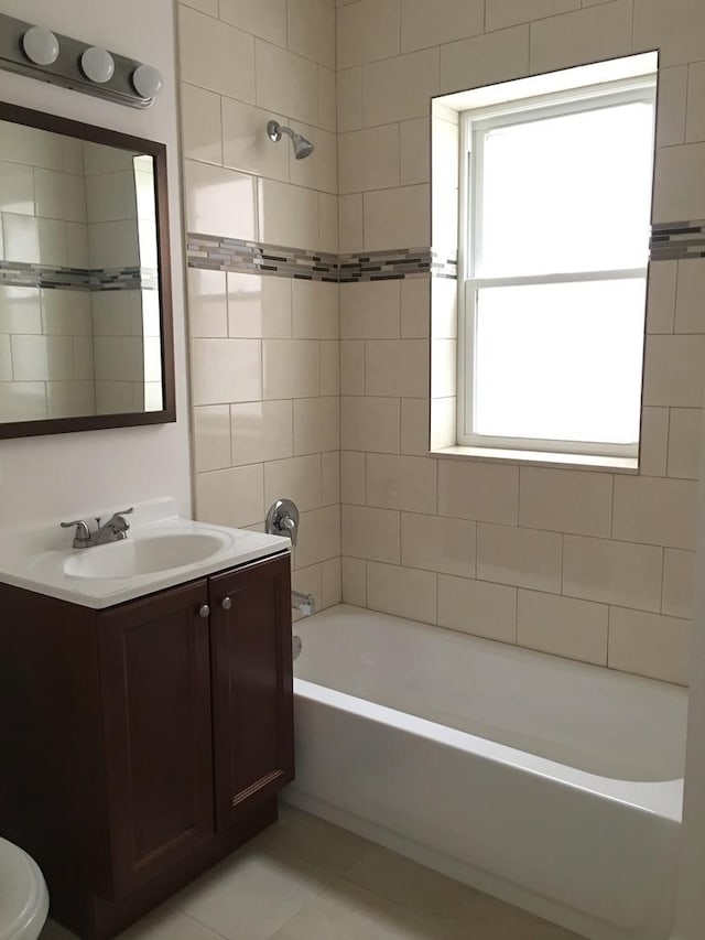 full bath with a healthy amount of sunlight, vanity, shower / bathing tub combination, and tile patterned flooring