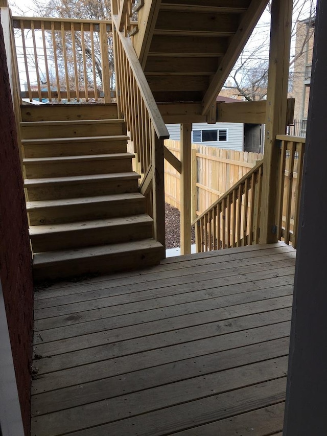 wooden terrace featuring fence and stairway