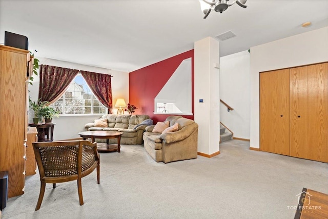 carpeted living area with stairway, visible vents, and baseboards