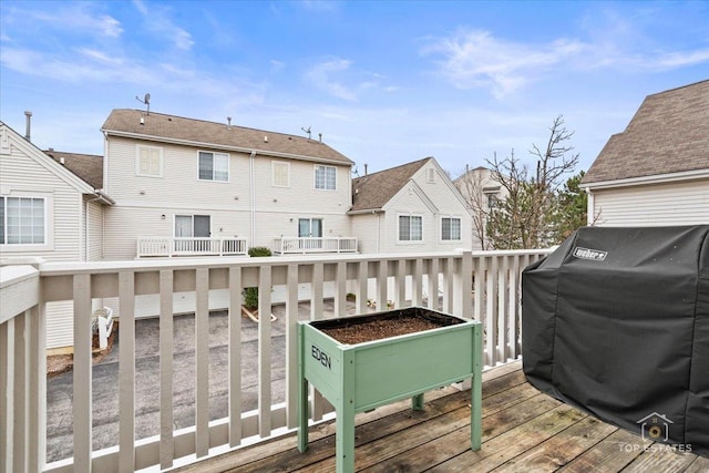 wooden terrace with grilling area and a residential view