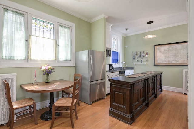 kitchen featuring hanging light fixtures, dark brown cabinetry, light wood-style floors, crown molding, and stainless steel appliances