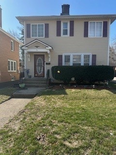 view of front of house with a chimney and a front yard